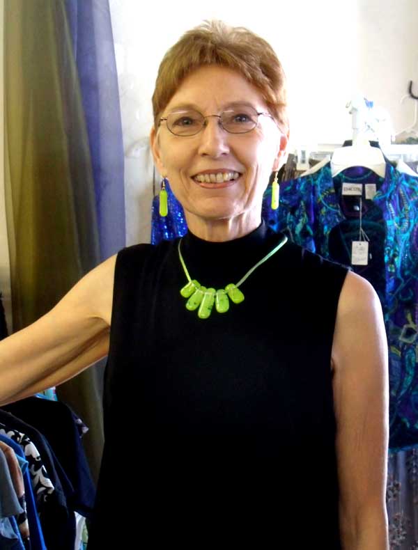 Bonnie, up close, in a black top and small five-piece lime green fused glass necklace and matching earrings