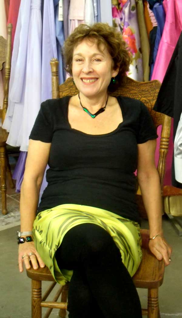 Jacqueline takes a break. Black top, green print skirt paired with a fused glass "V" of black and green-blue dichroic, matching earrings.