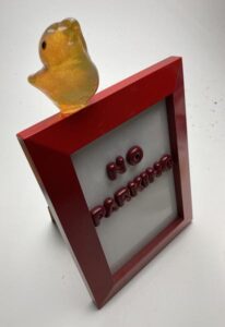 No Parking, a framed fused piece with a hot-sculpted bird atop it.
